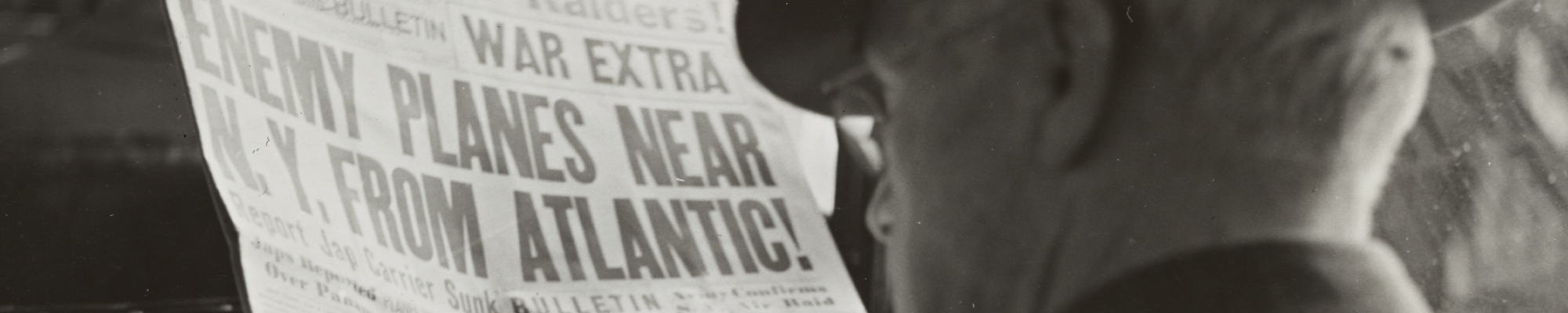 Man reading newspaper with headline war planes near NY